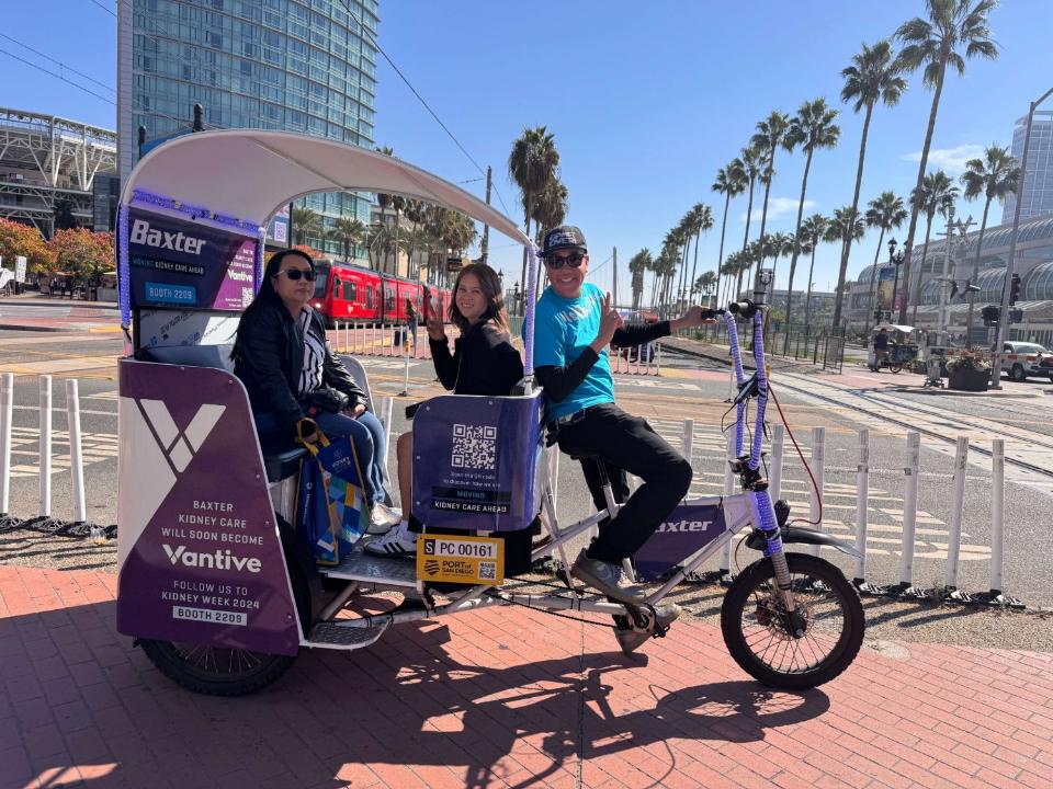 Two riders and their driver flashing peace signs by the trolley tracks downtown